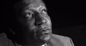 A black and white photo of a man looking up