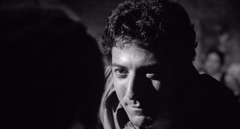 Movie still from “Lenny” (1974), directed by Bob Fosse – Black and white photograph of a young man looking into the camera; Close Up shot, Low angle