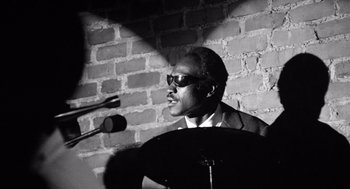 Movie still from “Lenny” (1974), directed by Bob Fosse – A black and white photo of a man in front of microphones; Close Up shot, Low angle