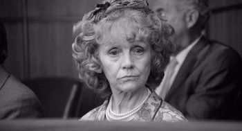 Movie still from “Lenny” (1974), directed by Bob Fosse – An older woman wearing a dress and pearls; Close Up shot, High angle