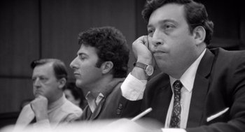 Movie still from “Lenny” (1974), directed by Bob Fosse – A black - and - white photo of three men sitting in front of each other; Close Up shot, Low angle