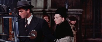 Movie still from “Les Girls” (1957), directed by George Cukor – A man and a woman in a crowd of onlookers; Close Up shot, Low angle