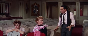 Movie still from “Les Girls” (1957), directed by George Cukor – A man and a woman are sitting in a living room; Medium shot, Low angle