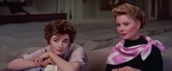 Movie still from “Les Girls” (1957), directed by George Cukor – Two beautiful women sitting on a couch in a living room; Close Up shot, Low angle