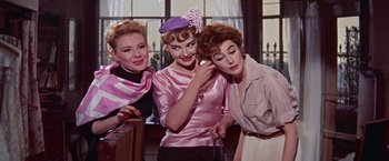 Movie still from “Les Girls” (1957), directed by George Cukor – A group of women standing next to each other in a room; Medium shot, Low angle