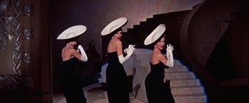 Movie still from “Les Girls” (1957), directed by George Cukor – A group of women in black dresses and white hats; Medium shot, Low angle