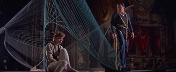 Movie still from “Les Girls” (1957), directed by George Cukor – A couple of people that are sitting on the ground; Wide shot, Low angle