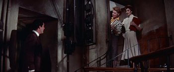 Movie still from “Les Girls” (1957), directed by George Cukor – A woman standing on a set of stairs; Medium shot, Low angle