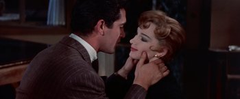 Movie still from “Les Girls” (1957), directed by George Cukor – A man and a woman touching each other's ear; Close Up shot, High angle