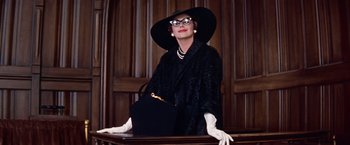 Movie still from “Les Girls” (1957), directed by George Cukor – An older woman wearing a hat and holding a purse; Medium shot, Low angle
