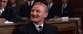 Movie still from “Les Girls” (1957), directed by George Cukor – A person wearing a suit and tie; Close Up shot, Low angle