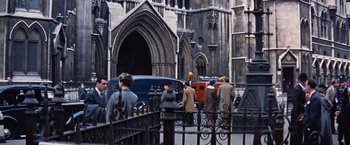 Movie still from “Les Girls” (1957), directed by George Cukor – A group of people standing in front of a building; Wide shot, High angle