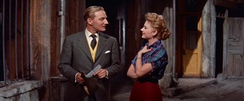 Movie still from “Les Girls” (1957), directed by George Cukor – A man and a woman standing next to each other; Medium shot, Low angle