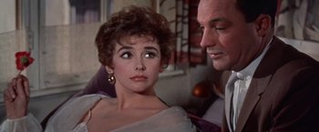 Movie still from “Les Girls” (1957), directed by George Cukor – An older man and a young woman looking at each other; Close Up shot, Over the shoulder angle