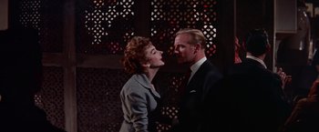 Movie still from “Les Girls” (1957), directed by George Cukor – A man and a woman standing next to each other; Medium shot, Low angle