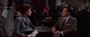 Movie still from “Les Girls” (1957), directed by George Cukor – A man and a woman sitting at a table in a restaurant; Medium shot, Over the shoulder angle