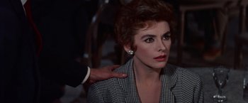 Movie still from “Les Girls” (1957), directed by George Cukor – A woman in a black and white checkered jacket and a man in a black and white checkered jacket; Close Up shot, Over the shoulder angle