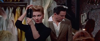Movie still from “Les Girls” (1957), directed by George Cukor – A man and a woman standing next to each other; Medium shot, Low angle