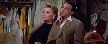 Movie still from “Les Girls” (1957), directed by George Cukor – A man and a woman standing next to each other; Medium shot, Low angle