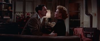 Movie still from “Les Girls” (1957), directed by George Cukor – A man and a woman sitting next to each other on a couch; Medium shot, Low angle