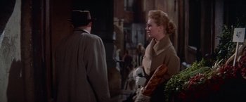 Movie still from “Les Girls” (1957), directed by George Cukor – A man and a woman are standing in the street; Medium shot, Over the shoulder angle