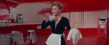 Movie still from “Les Girls” (1957), directed by George Cukor – A woman in a black dress holding a wine glass; Medium shot, Low angle
