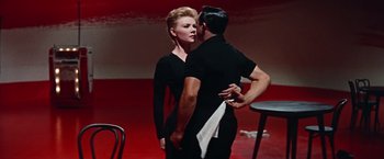 Movie still from “Les Girls” (1957), directed by George Cukor – A man and a woman in a black dress; Medium shot, Low angle