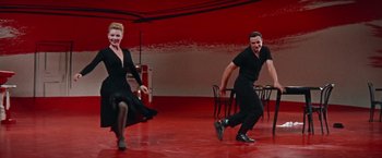 Movie still from “Les Girls” (1957), directed by George Cukor – A man and a woman are dancing on a stage; Wide shot, Low angle
