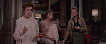 Movie still from “Les Girls” (1957), directed by George Cukor – A group of women standing next to each other in a room; Medium shot, Low angle