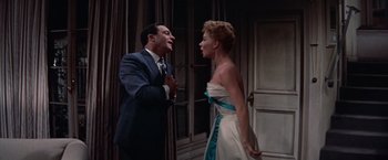 Movie still from “Les Girls” (1957), directed by George Cukor – A man and a woman are standing next to each other; Medium shot, Low angle