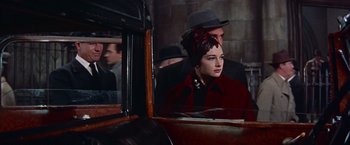 Movie still from “Les Girls” (1957), directed by George Cukor – A man and a woman are standing in front of a car; Medium shot, Over the shoulder angle