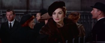 Movie still from “Les Girls” (1957), directed by George Cukor – A woman wearing a hat and a fur coat; Close Up shot, Low angle