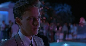 Movie still from “Less Than Zero” (1987), directed by Marek Kanievska – A man in a suit and tie looking to his left; Close Up shot, Low angle