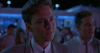 Movie still from “Less Than Zero” (1987), directed by Marek Kanievska – A man in a suit and tie looking to his left; Close Up shot, Low angle