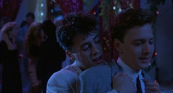 Movie still from “Less Than Zero” (1987), directed by Marek Kanievska – Two young men hugging each other at a party; Close Up shot, Over the shoulder angle
