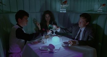 Movie still from “Less Than Zero” (1987), directed by Marek Kanievska – A group of people sitting at a table in a restaurant; Medium shot, High angle