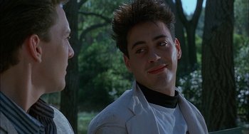 Movie still from “Less Than Zero” (1987), directed by Marek Kanievska – A man in a white jacket is talking to another man in a white jacket; Close Up shot, Over the shoulder angle