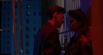 Movie still from “Less Than Zero” (1987), directed by Marek Kanievska – A man and a woman standing next to each other in front of a building; Medium shot, Over the shoulder angle