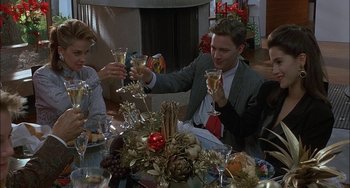Movie still from “Less Than Zero” (1987), directed by Marek Kanievska – A group of people sitting around a table with wine glasses; Medium shot, Low angle