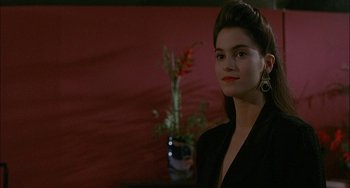 Movie still from “Less Than Zero” (1987), directed by Marek Kanievska – A woman in a black jacket standing in front of a red wall; Close Up shot, Over the shoulder angle