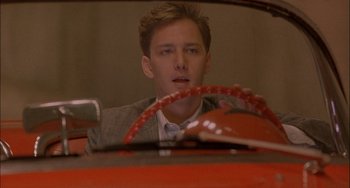 Movie still from “Less Than Zero” (1987), directed by Marek Kanievska – A man sitting in the driver's seat of a car; Close Up shot, Over the shoulder angle