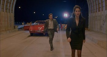 Movie still from “Less Than Zero” (1987), directed by Marek Kanievska – A man and a woman are walking down the street; Wide shot, High angle