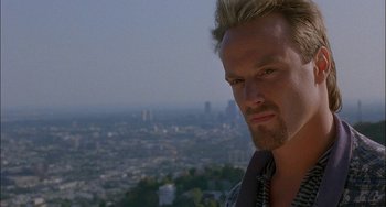 Movie still from “Less Than Zero” (1987), directed by Marek Kanievska – A person with a city in the background; Close Up shot, Over the shoulder angle