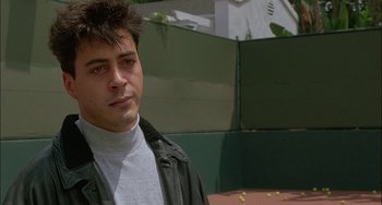 Movie still from “Less Than Zero” (1987), directed by Marek Kanievska – A young man in a black leather jacket and a white shirt; Close Up shot, Over the shoulder angle