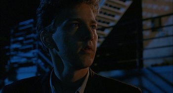 Movie still from “Less Than Zero” (1987), directed by Marek Kanievska – A man in a suit looking to his left; Close Up shot, Low angle