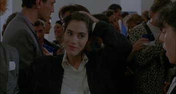 Movie still from “Less Than Zero” (1987), directed by Marek Kanievska – A woman in a crowd of people with her hands in her hair; Close Up shot, Over the shoulder angle