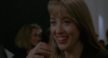 Movie still from “Less Than Zero” (1987), directed by Marek Kanievska – A person with a smile on their face; Close Up shot, Over the shoulder angle