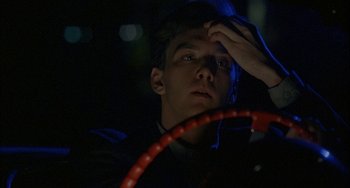 Movie still from “Less Than Zero” (1987), directed by Marek Kanievska – A man holding a hula hoop in his hand; Close Up shot, Low angle