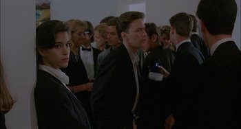 Movie still from “Less Than Zero” (1987), directed by Marek Kanievska – A group of people standing in a room; Medium shot, Over the shoulder angle