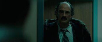 Movie still from “Let Me In” (2010), directed by Matt Reeves – A man in a suit and tie standing in front of a window; Close Up shot, Over the shoulder angle